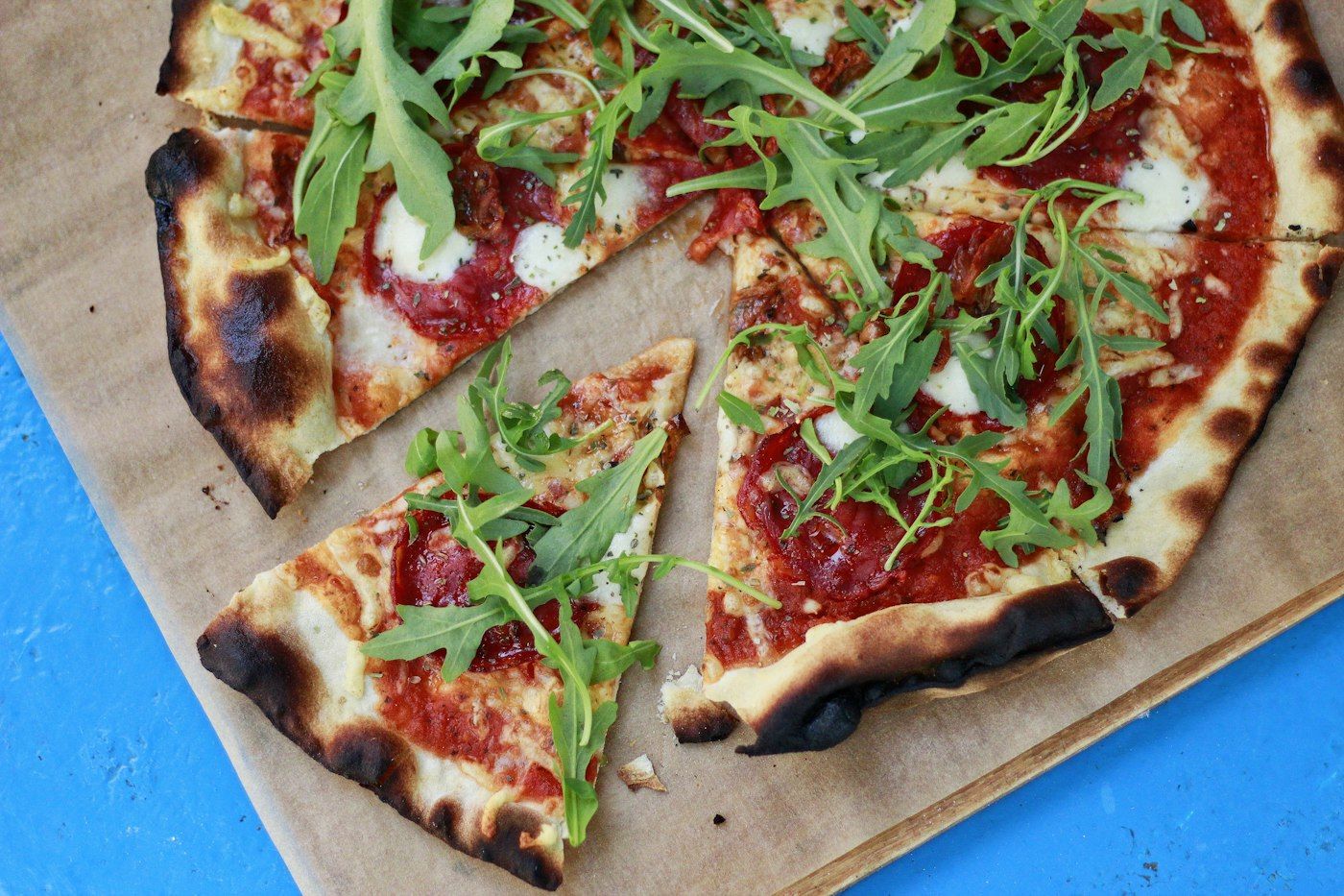 Pizza con rucola su carta da forno
