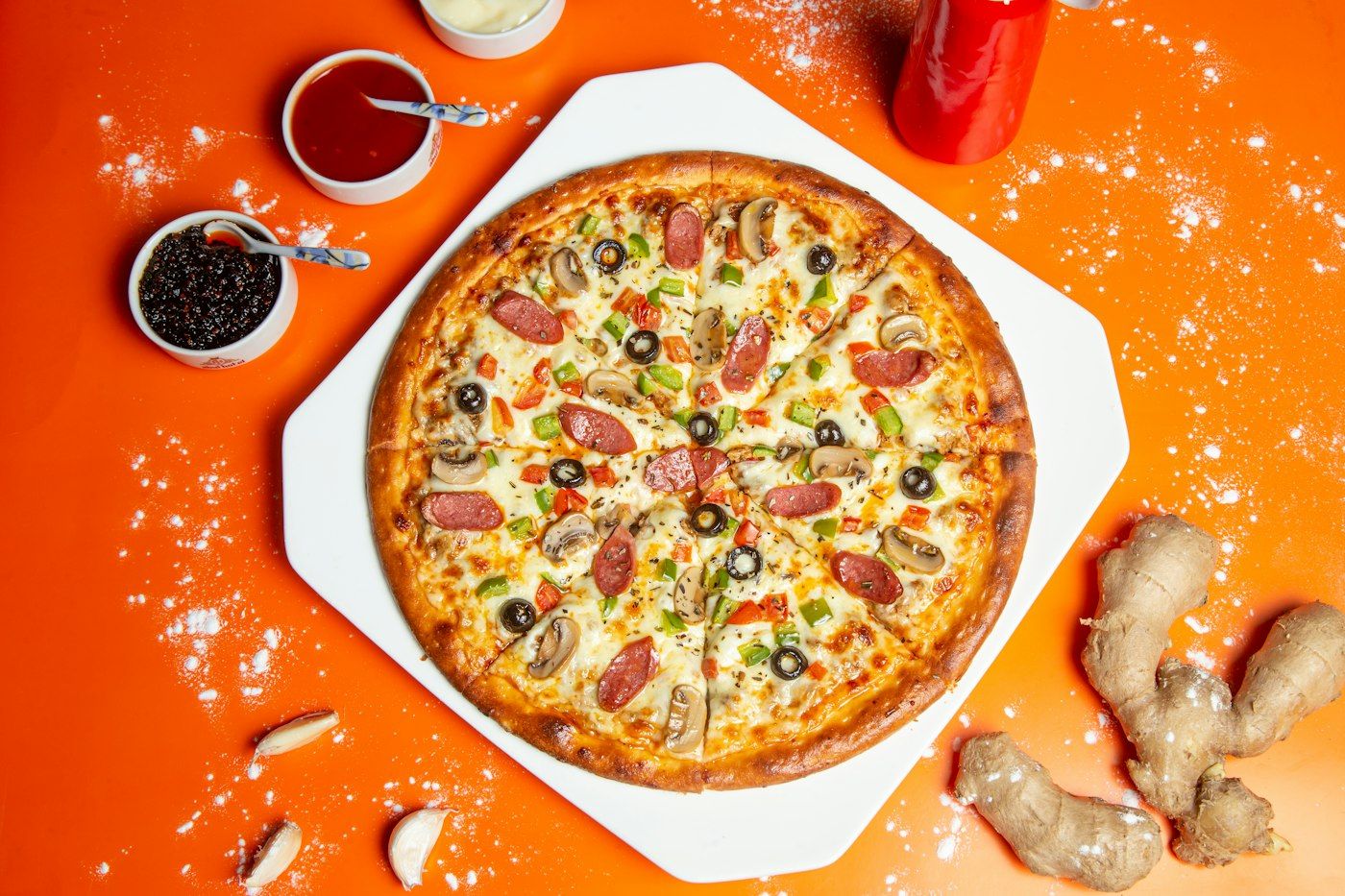 Pizza con pomodorini e olive su fondo arancione